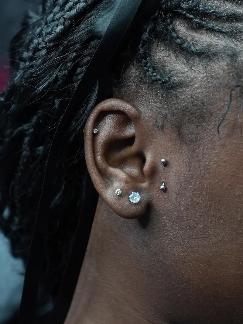 Conch, tragus and lobe stack — piercing by Foenix Ink, Hollywood FL, implant-grade titanium (1/3)