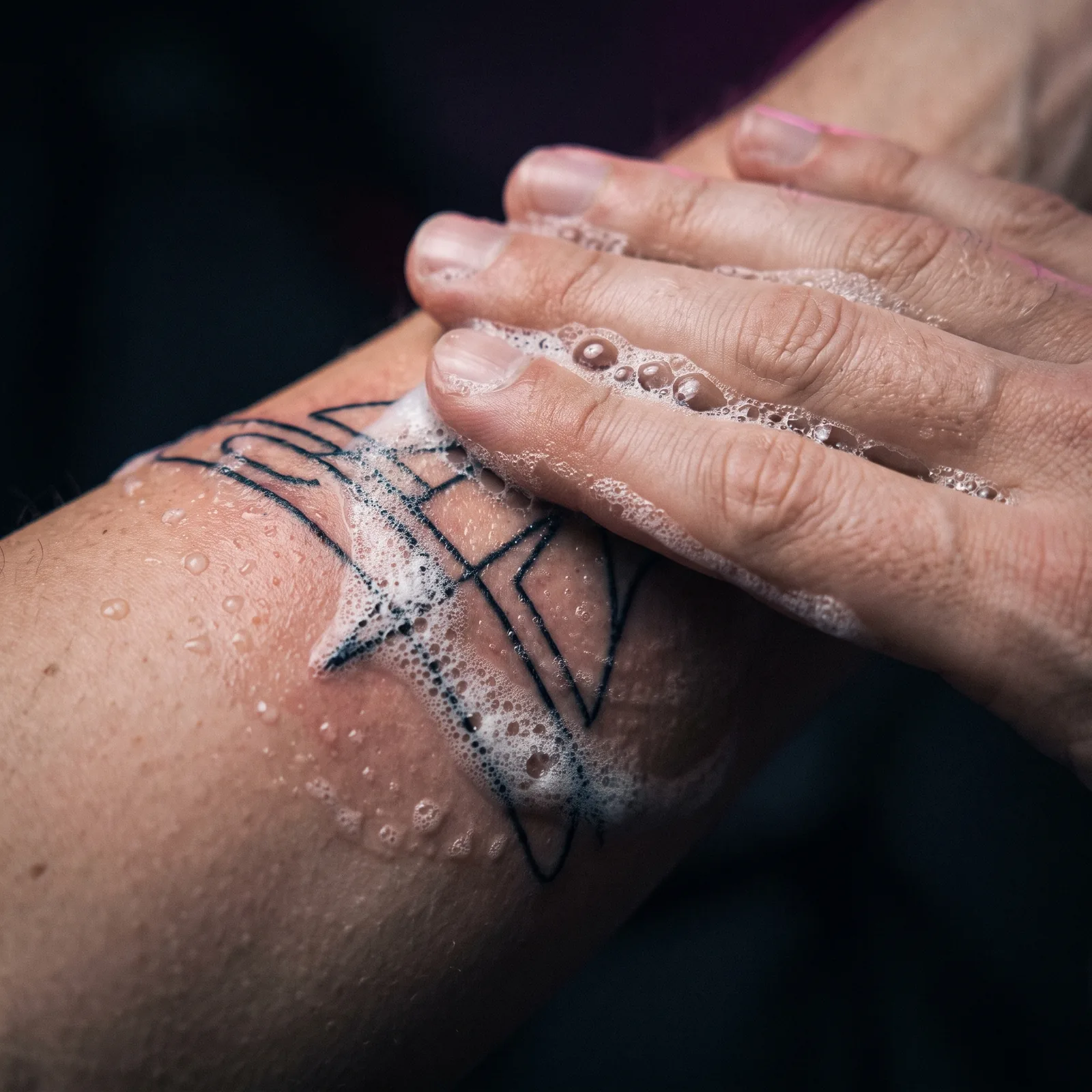 Fresh tattoo being gently cleaned with fragrance-free soap and water