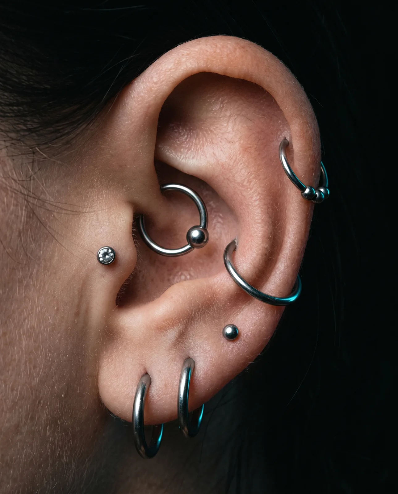 Healed curated ear piercing stack with titanium hoops and studs