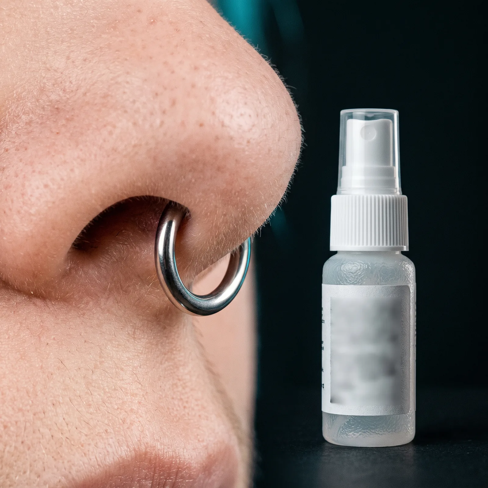 Saline aftercare spray next to a healed septum piercing