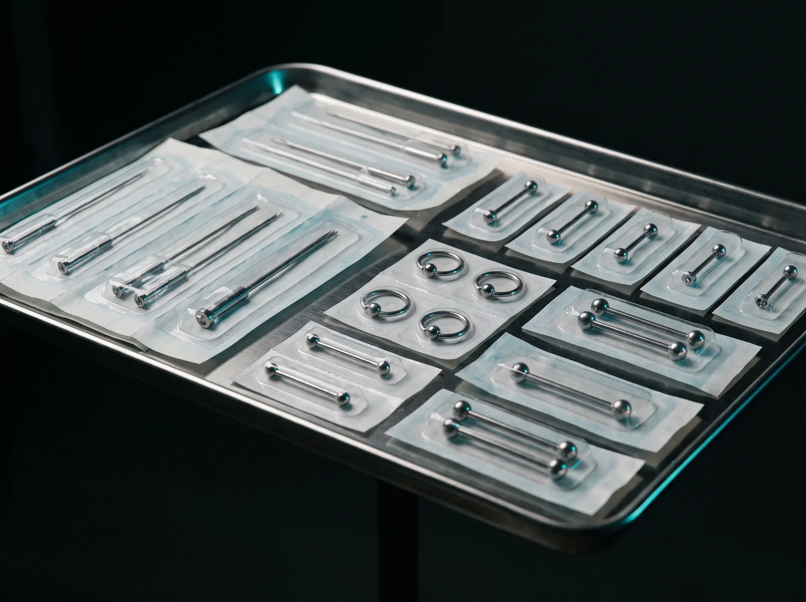 Sterile piercing station with sealed jewelry and single-use needles