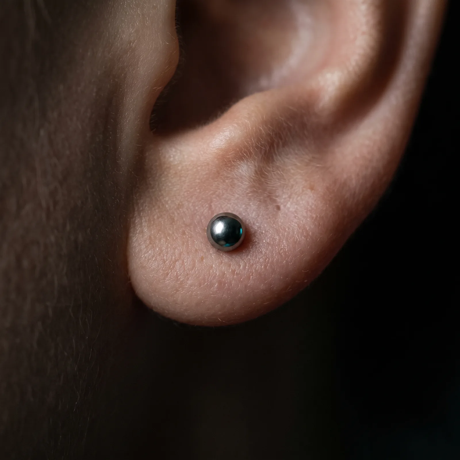 Close-up of a simple healed lobe piercing with implant-grade jewelry