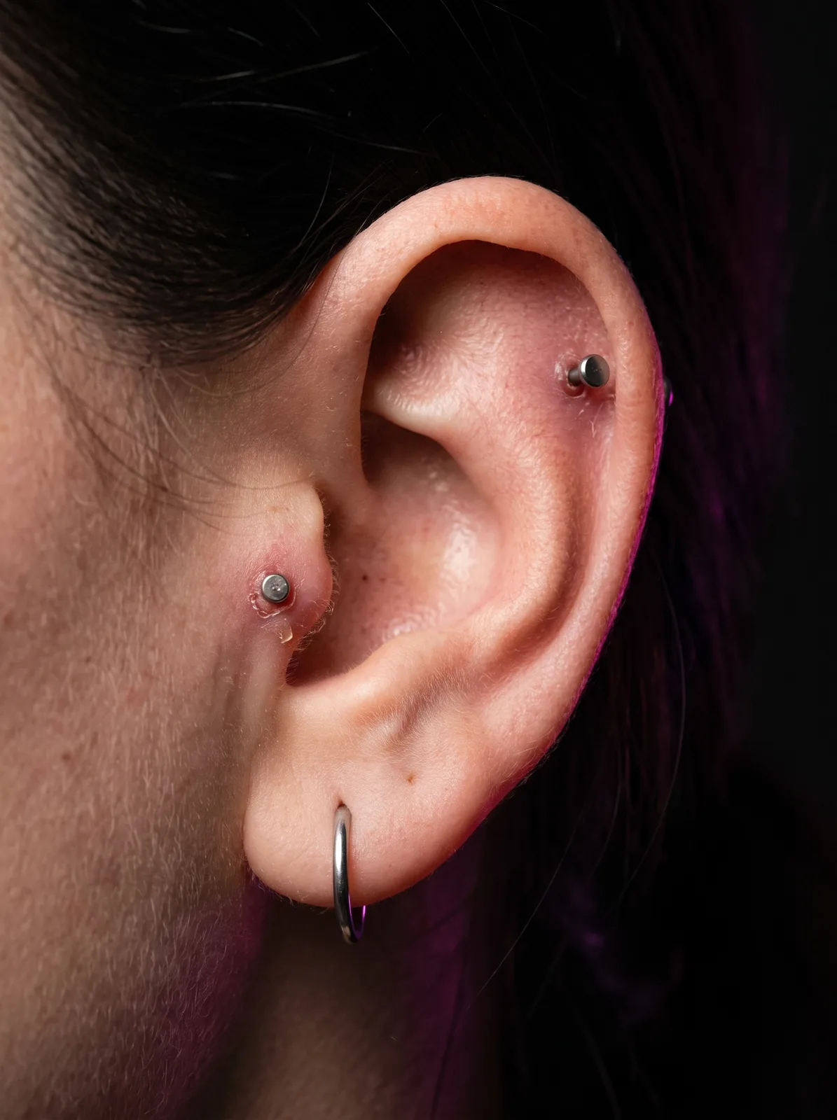 Ear stack showing piercings at different healing stages, built gradually over several visits